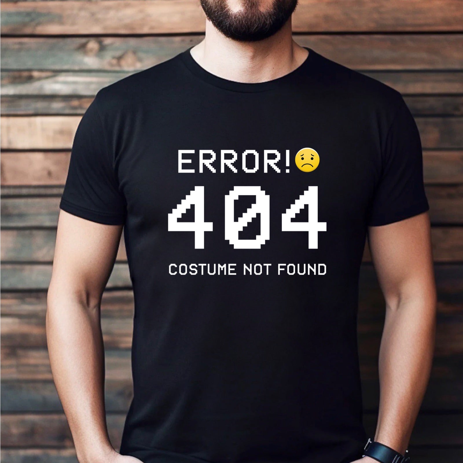 Man modeling a black crew-neck T-shirt with white pixel text Error 404 Costume Not Found and sad emoji graphic.