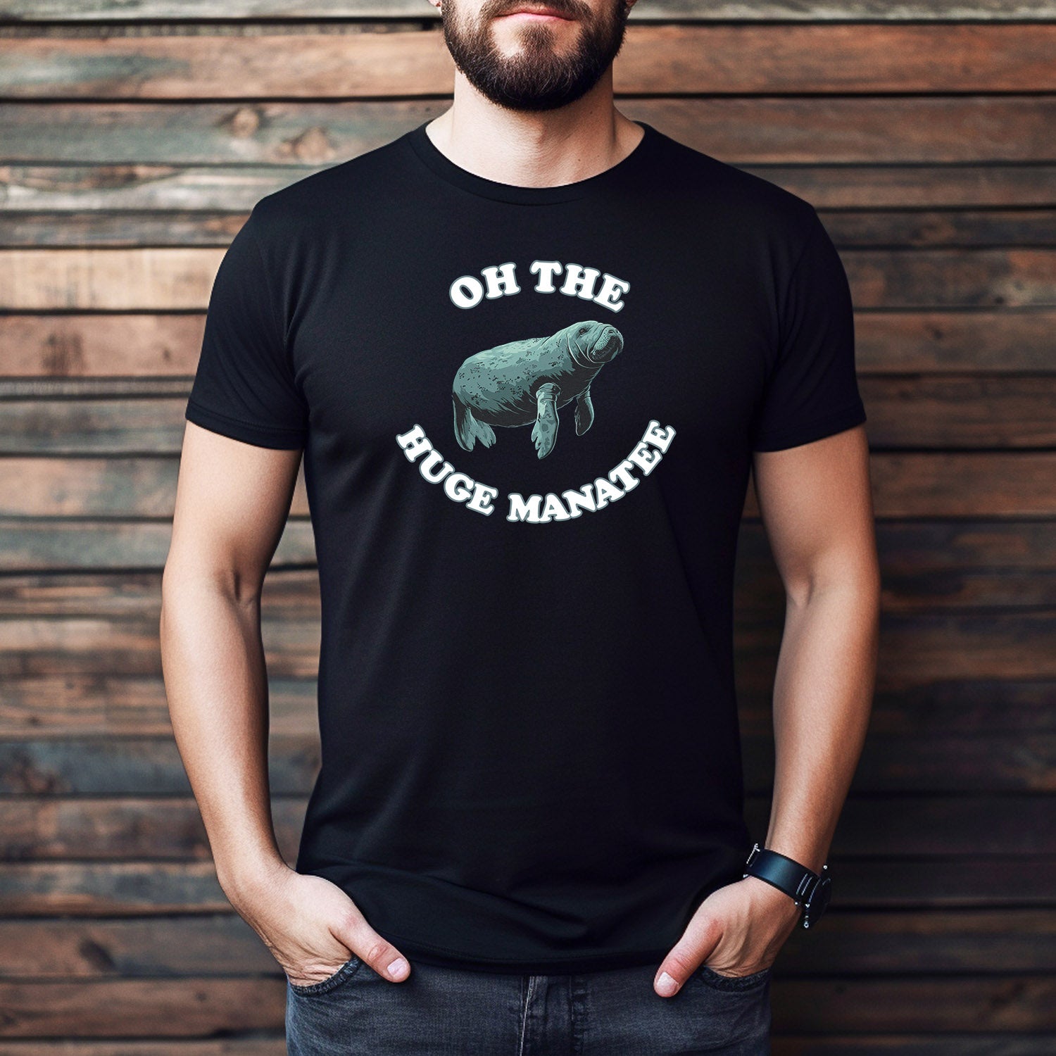 Man wearing black graphic t-shirt with funny manatee illustration and “Oh the Huge Manatee” text.