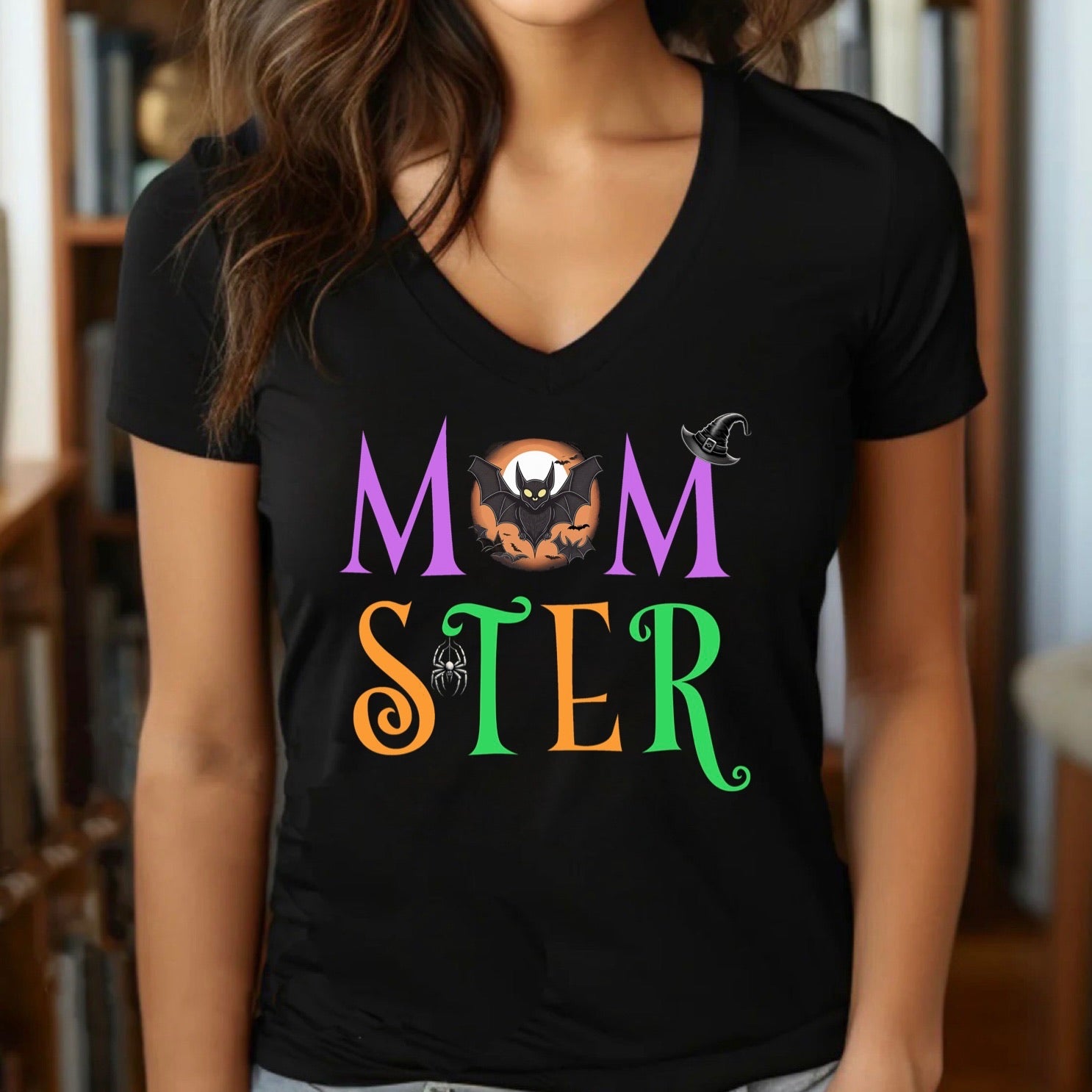 Woman wearing Momster Halloween v-neck shirt with spooky bat, witch hat, and spider accents.