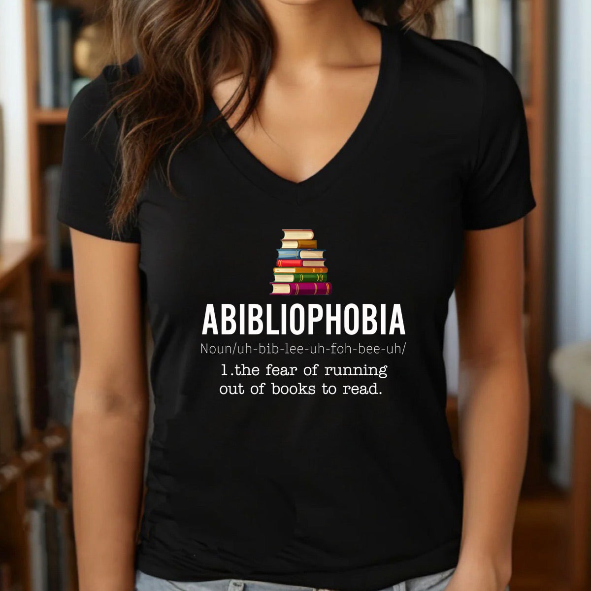 Woman wearing v-neck Abibliophobia shirt with book stack and funny definition, gift idea for readers