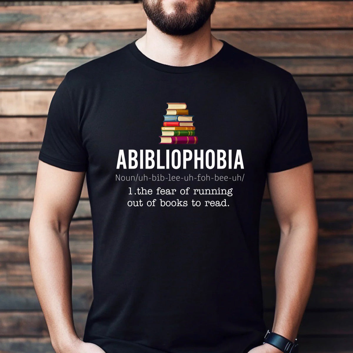 Man wearing Abibliophobia definition t-shirt with book stack graphic, funny reading shirt for bookworms