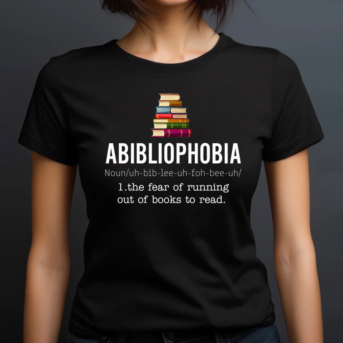 Woman in crew neck Abibliophobia shirt featuring book stack and definition about fear of no books to read