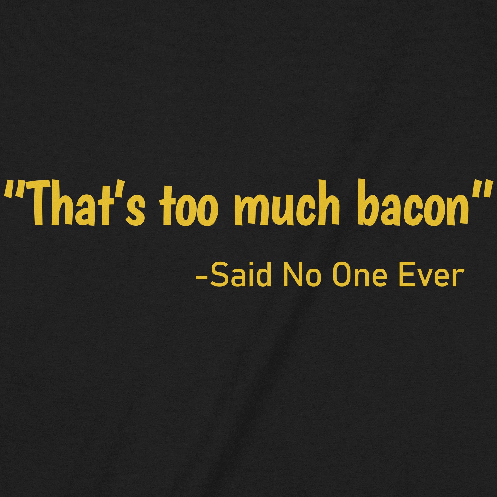 Closeup of black t-shirt with yellow text that reads That's too much bacon said no one ever in bold font