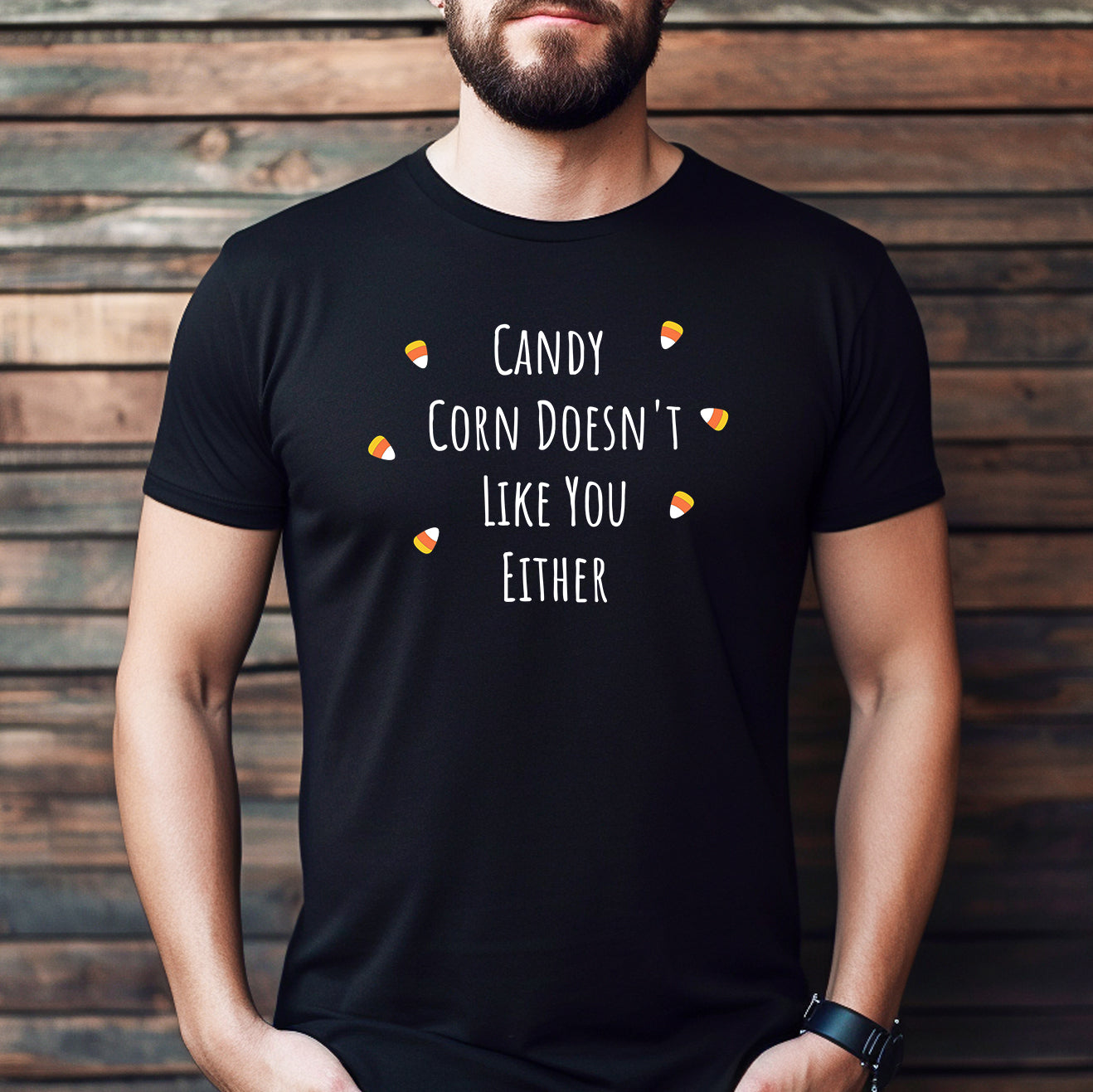 Man wearing black Halloween tee with candy corn design and text Candy Corn Doesn't Like You Either.