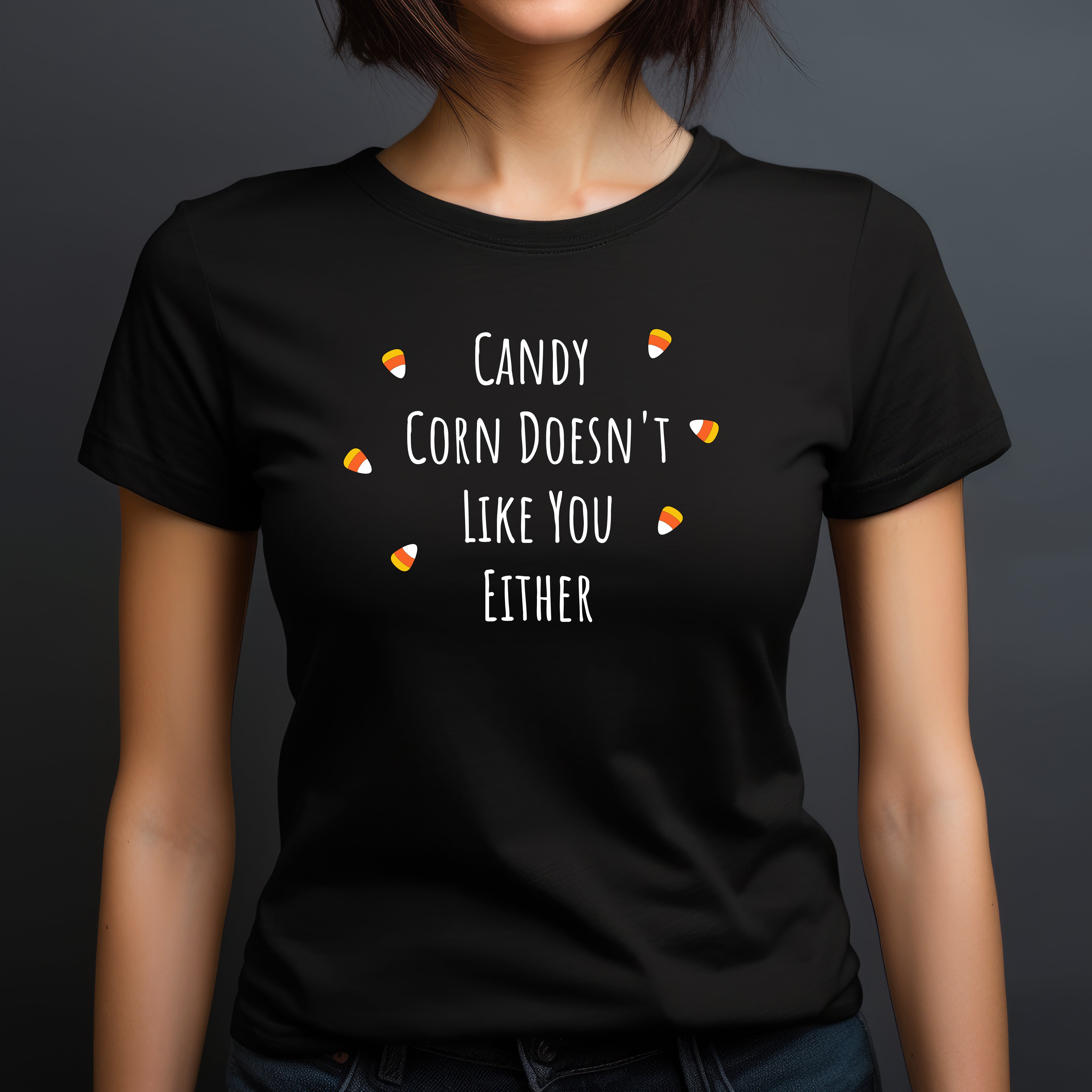 Woman wearing fitted black Halloween t-shirt featuring candy corn graphics and text Candy Corn Doesn't Like You Either.