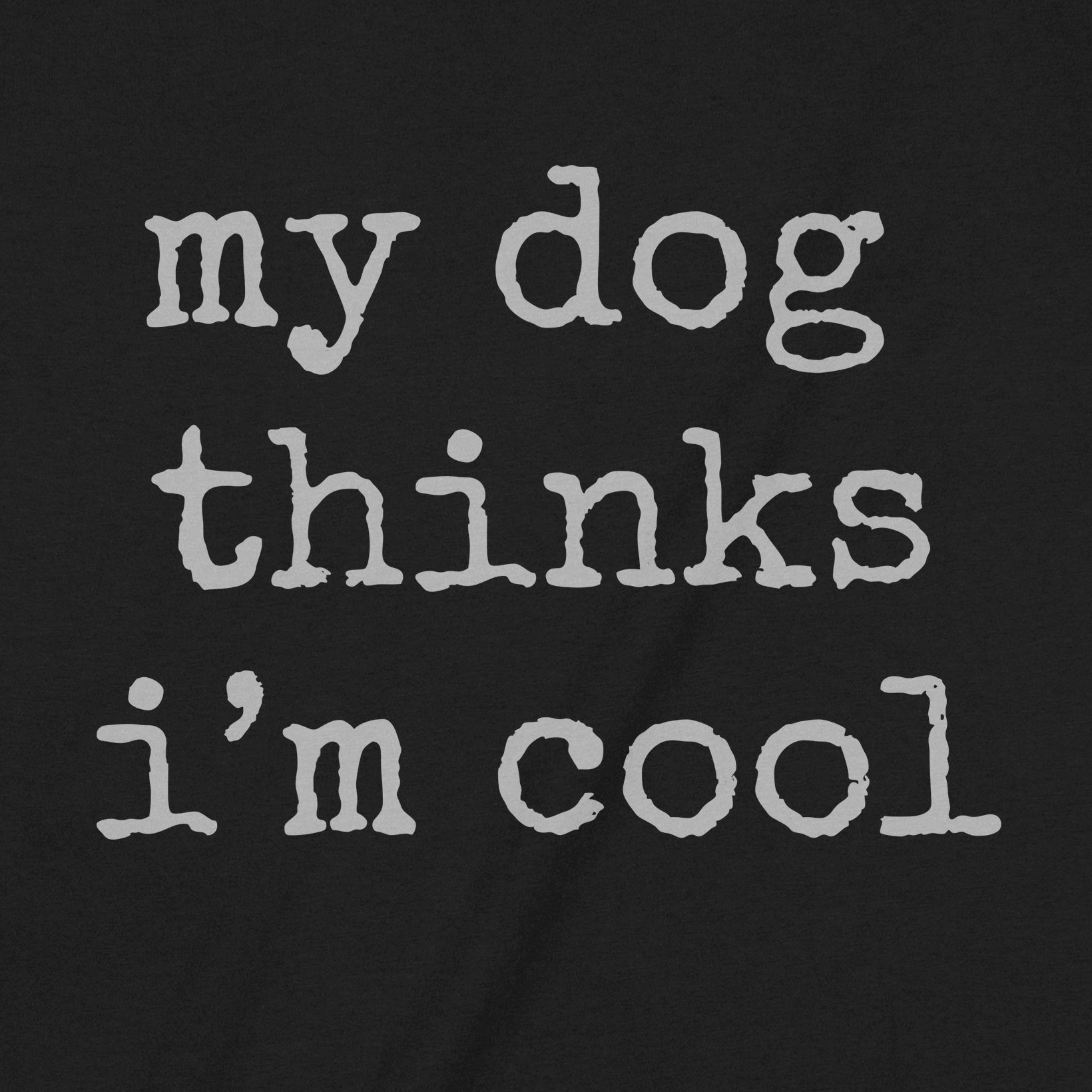 Close-up view of black graphic tee with the text “my dog thinks I’m cool” in bold white letters.