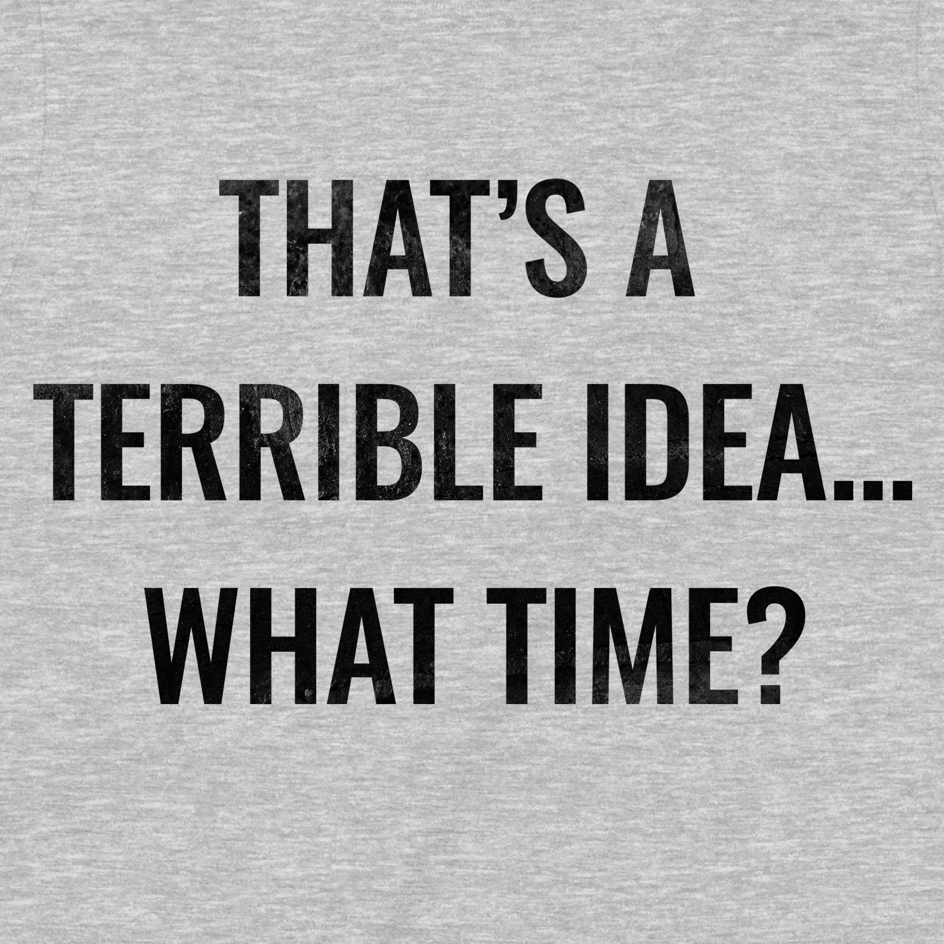 Close-up of the text print on a grey t-shirt that reads "That's a terrible idea… what time?" in black letters