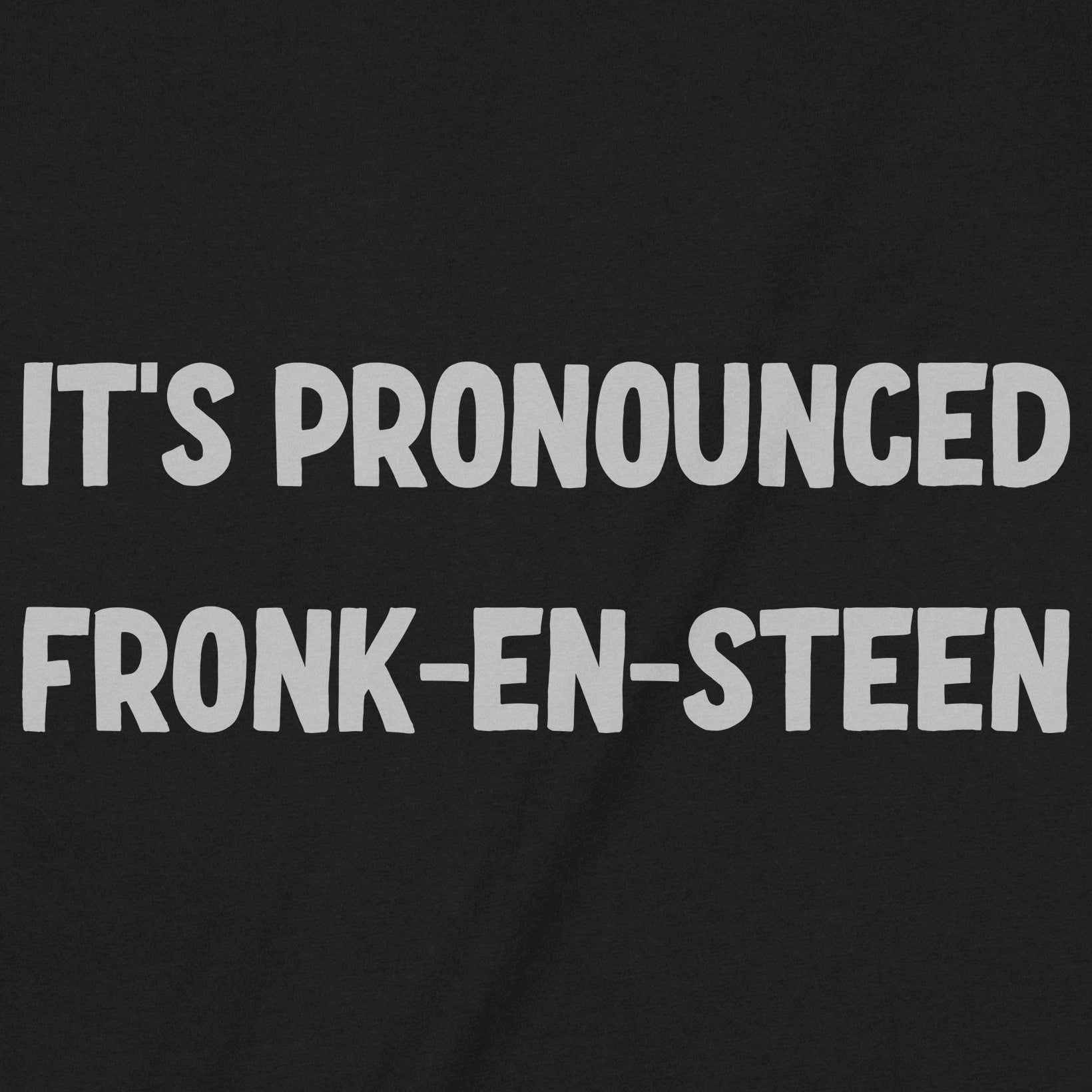 Close-up of black Halloween t-shirt with white bold text saying It’s Pronounced Fronk-en-Steen.