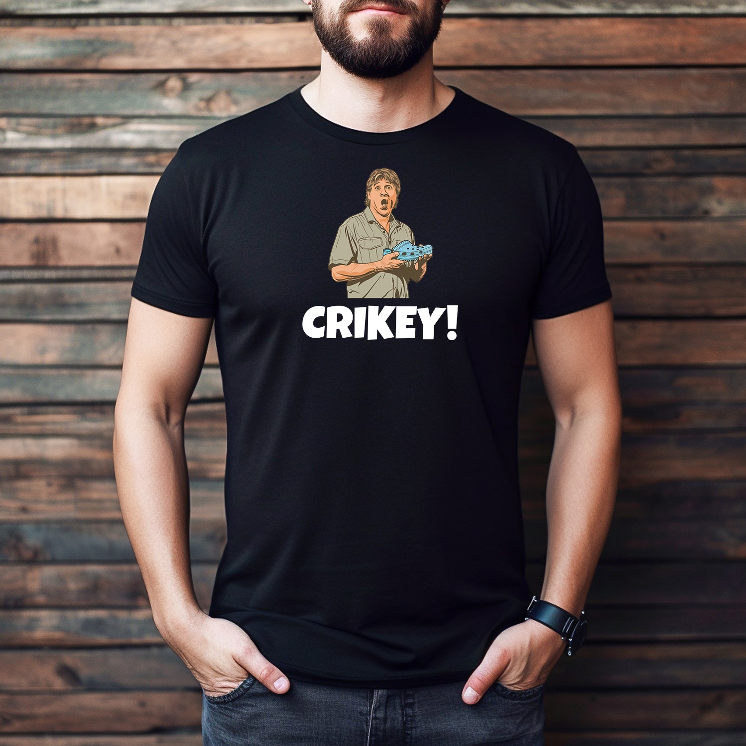 Man wearing black Crikey t-shirt featuring illustrated man with crocodile and bold text