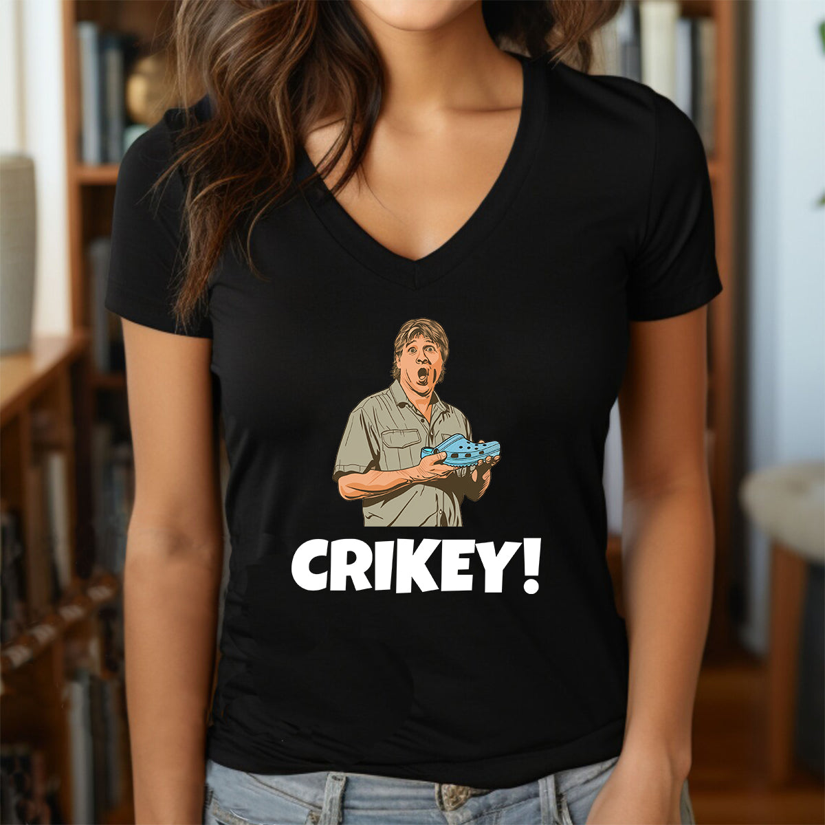 Woman in black v-neck Crikey shirt with illustrated crocodile graphic and bold text