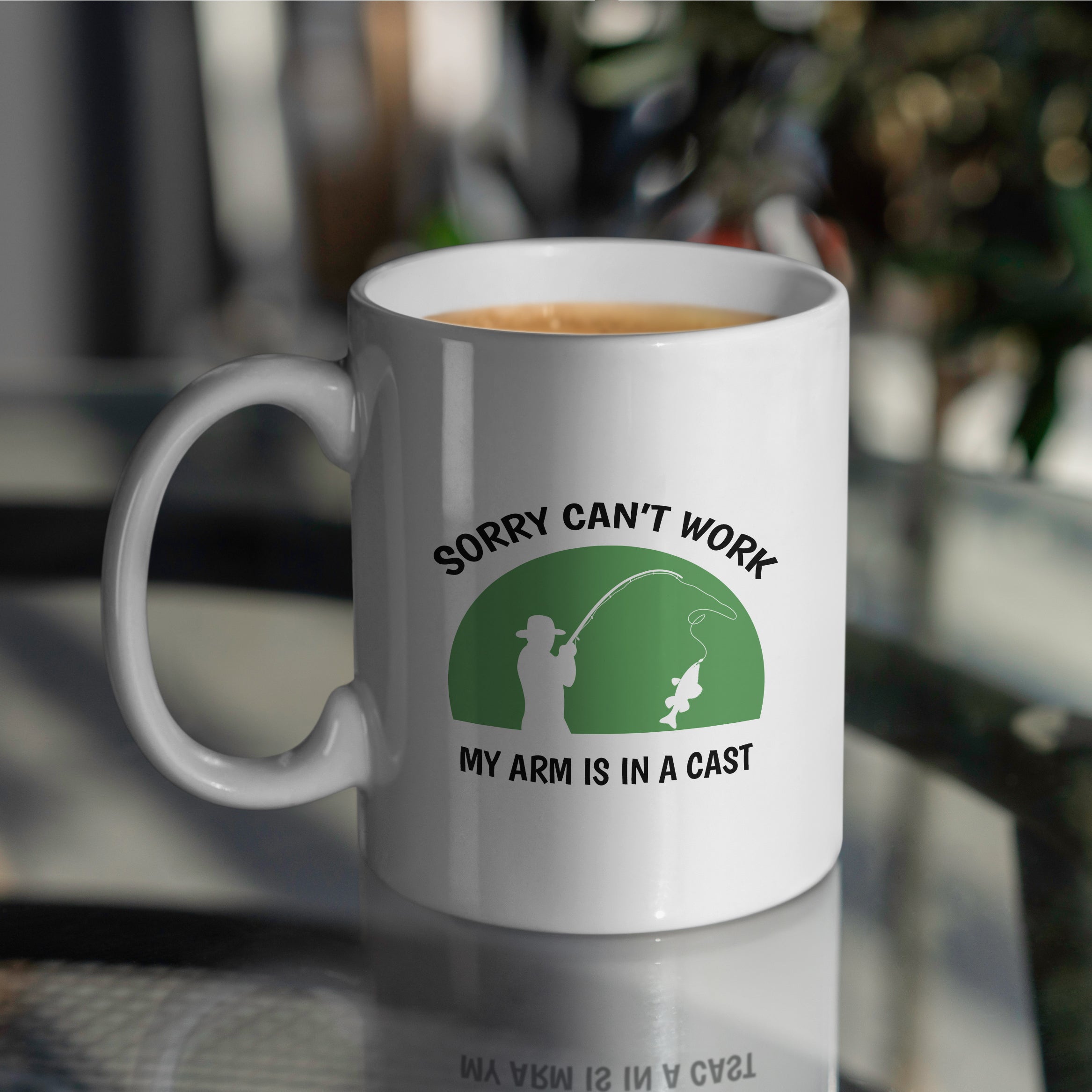 White ceramic fishing mug on table with sorry cant work arm in a cast design perfect gift for fishermen