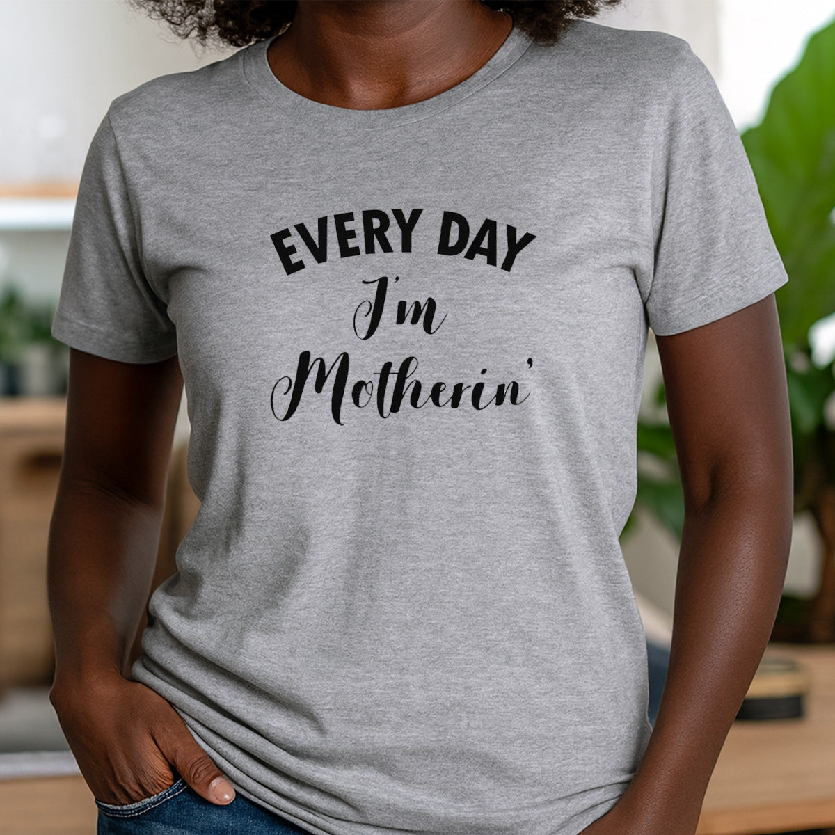 Woman in crew neck grey t-shirt featuring the quote Every Day I'm Motherin'