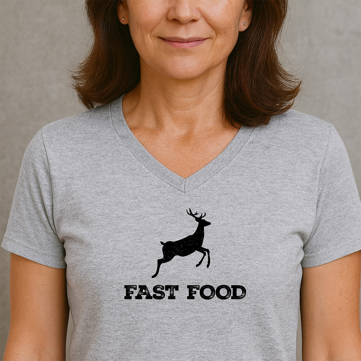 Woman in grey v-neck t-shirt featuring a running deer silhouette and text fast food