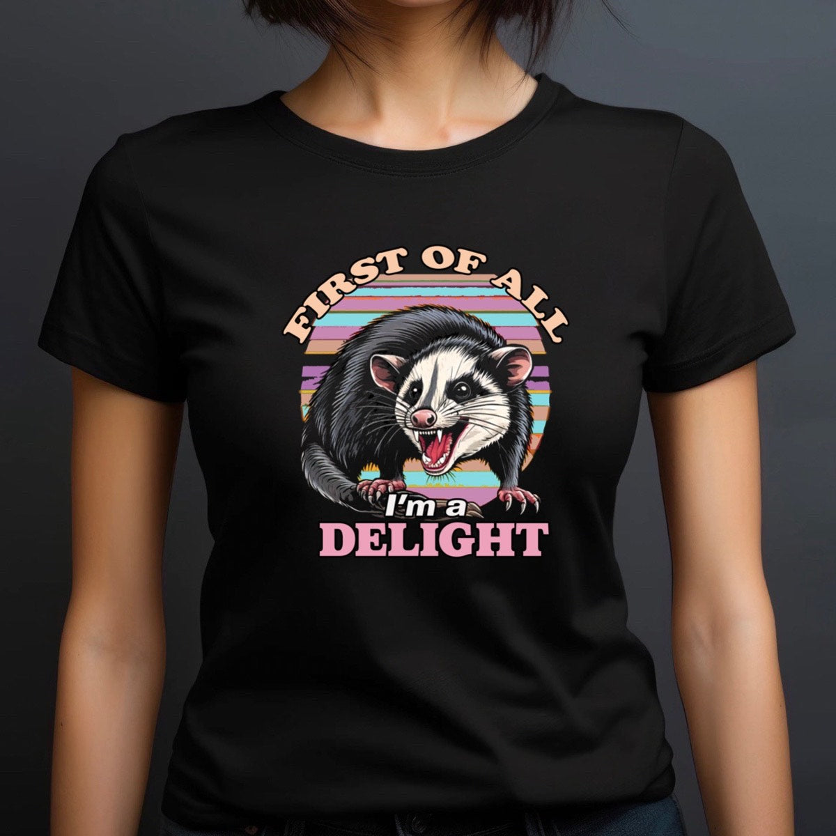 Woman wearing black crewneck tee with opossum graphic and retro sunset stripes, text First of all I’m a delight