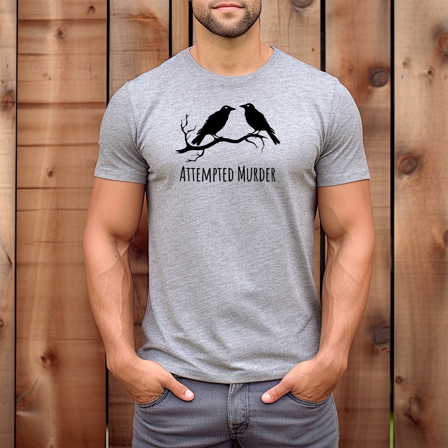 Men’s gray crewneck t-shirt featuring two crows and Attempted Murder text, humorous graphic tee for bird lovers and pun fans