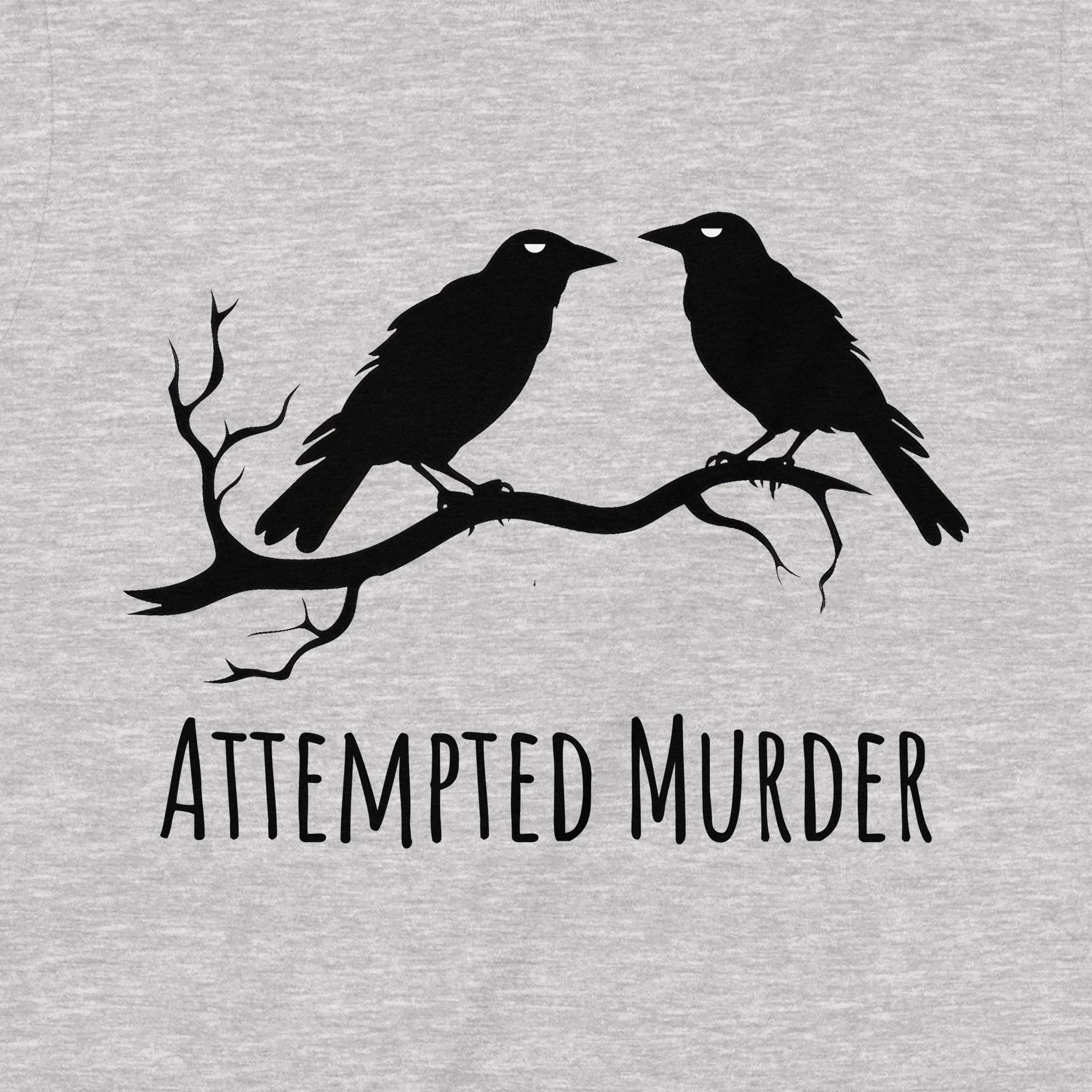 Closeup of gray tee with two crows on branch and Attempted Murder slogan, clever bird pun shirt for casual funny fashion