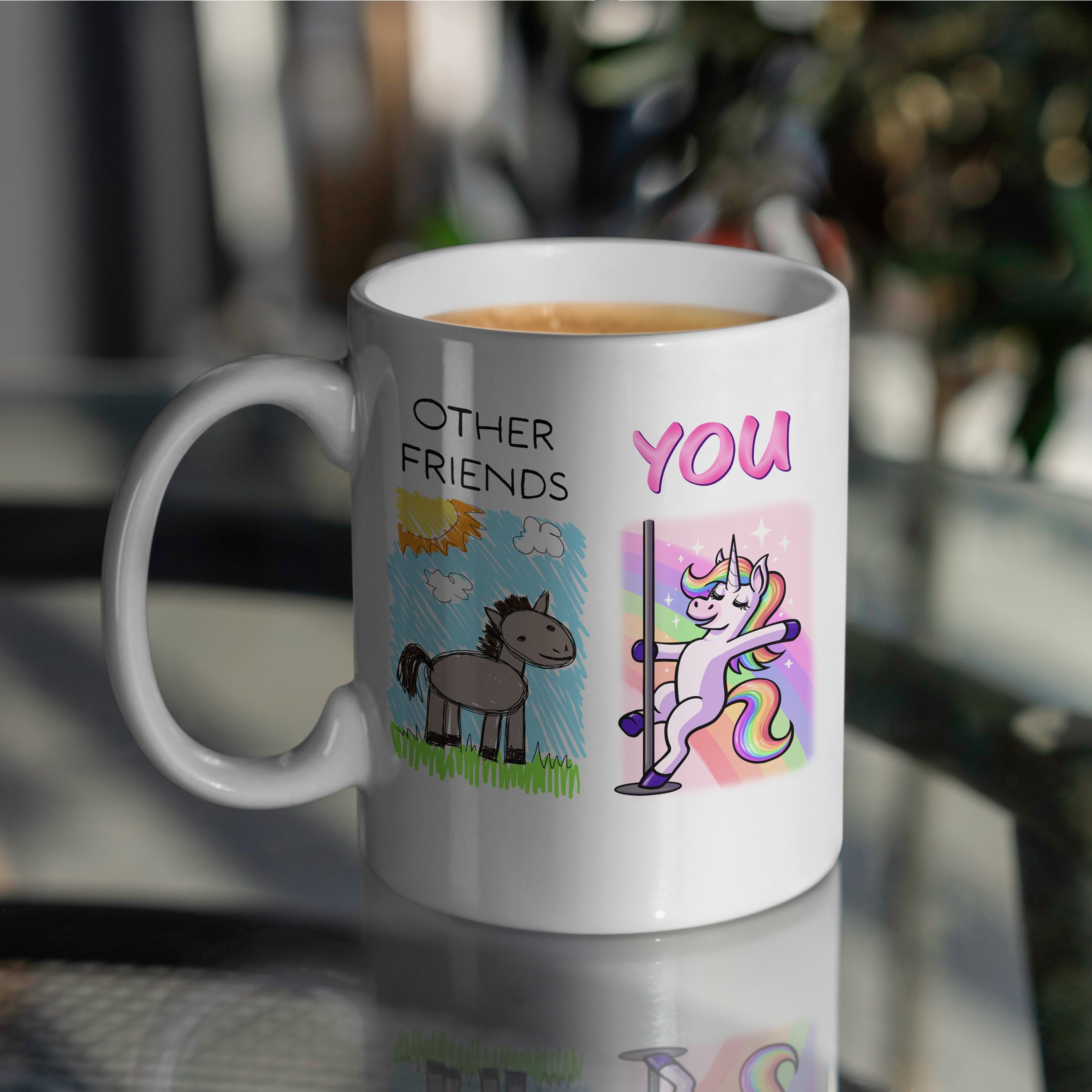 White ceramic friends mug with unicorn vs cartoon horse doodle design on table
