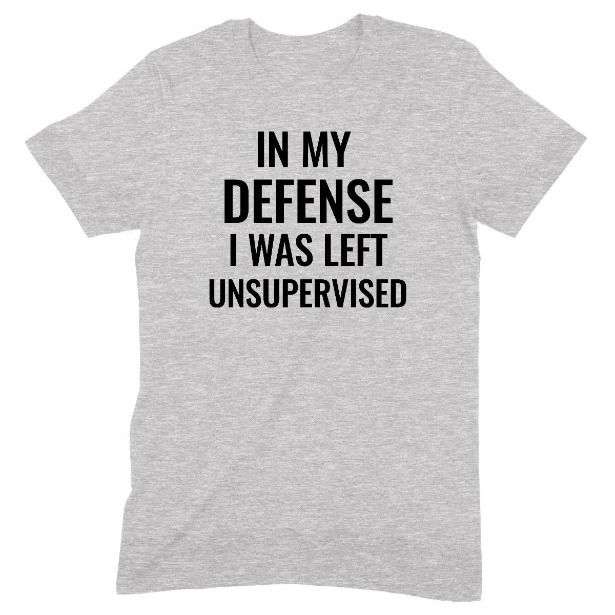 Flat lay of grey unisex graphic t-shirt with bold black text saying “In My Defense I Was Left Unsupervised