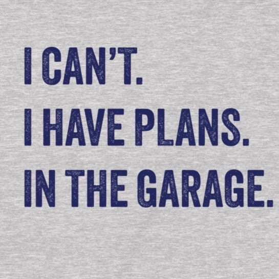 Closeup of grey t-shirt with navy motivational quote I can’t I have plans in the garage