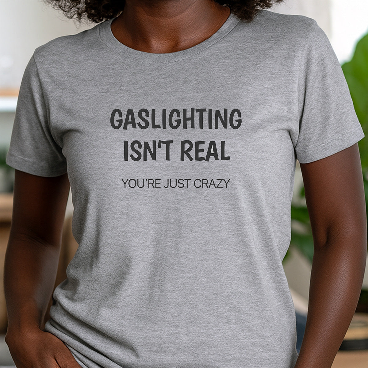 Woman in gray crew neck t-shirt featuring witty phrase gaslighting isn’t real you’re just crazy