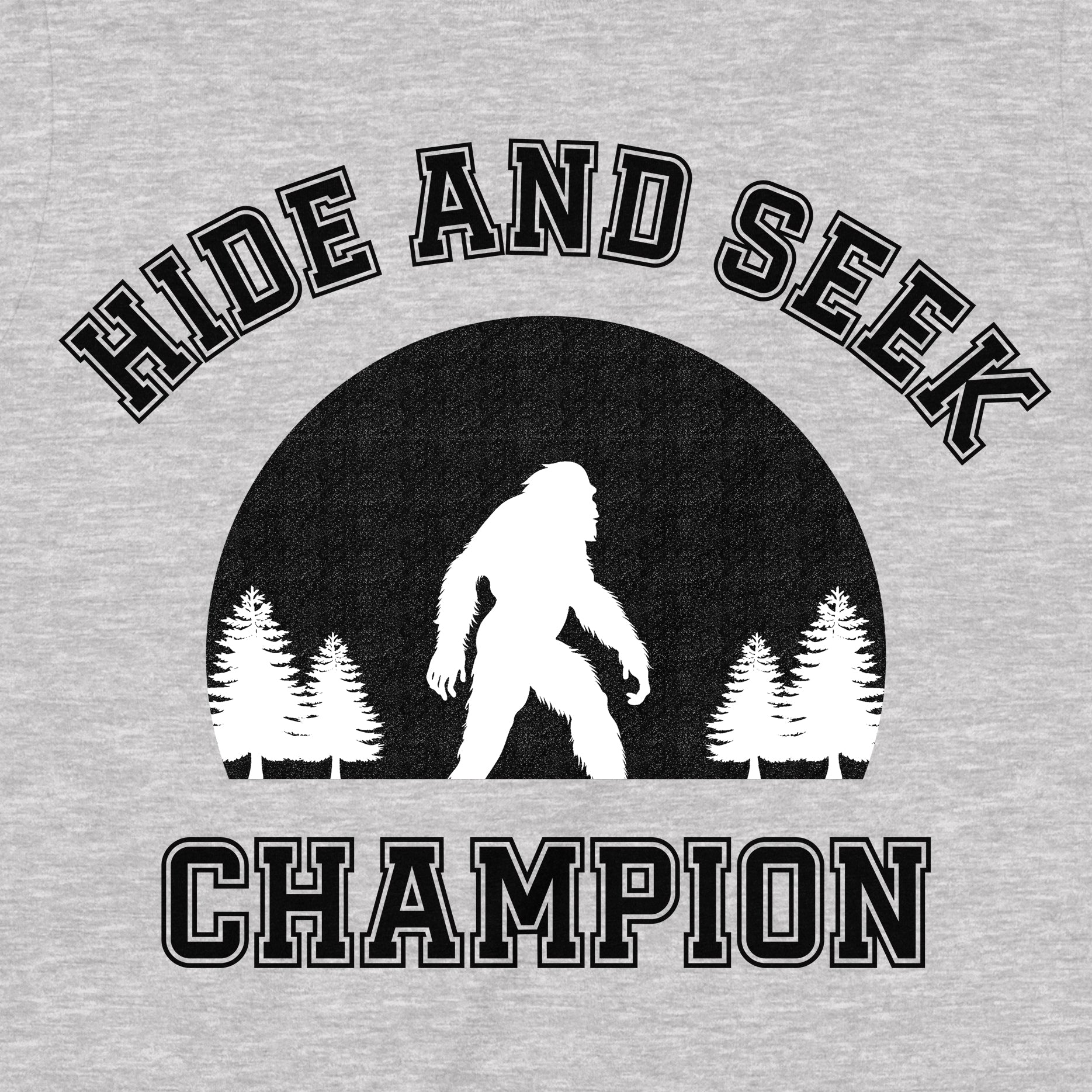Closeup of grey shirt with bold text Hide and Seek Champion and Bigfoot silhouette in forest design