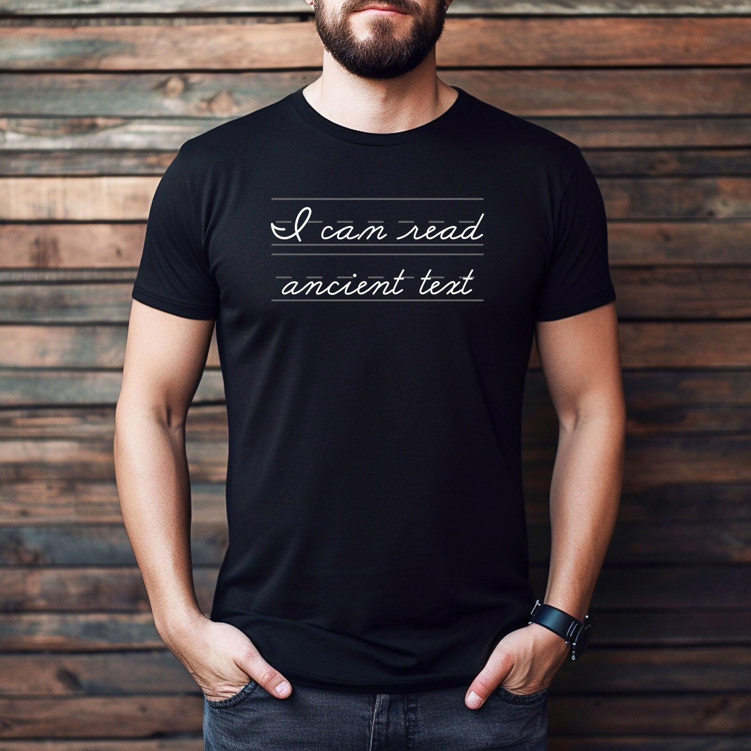 Man wearing black t-shirt with cursive text “I can read ancient text” written in handwriting practice style.