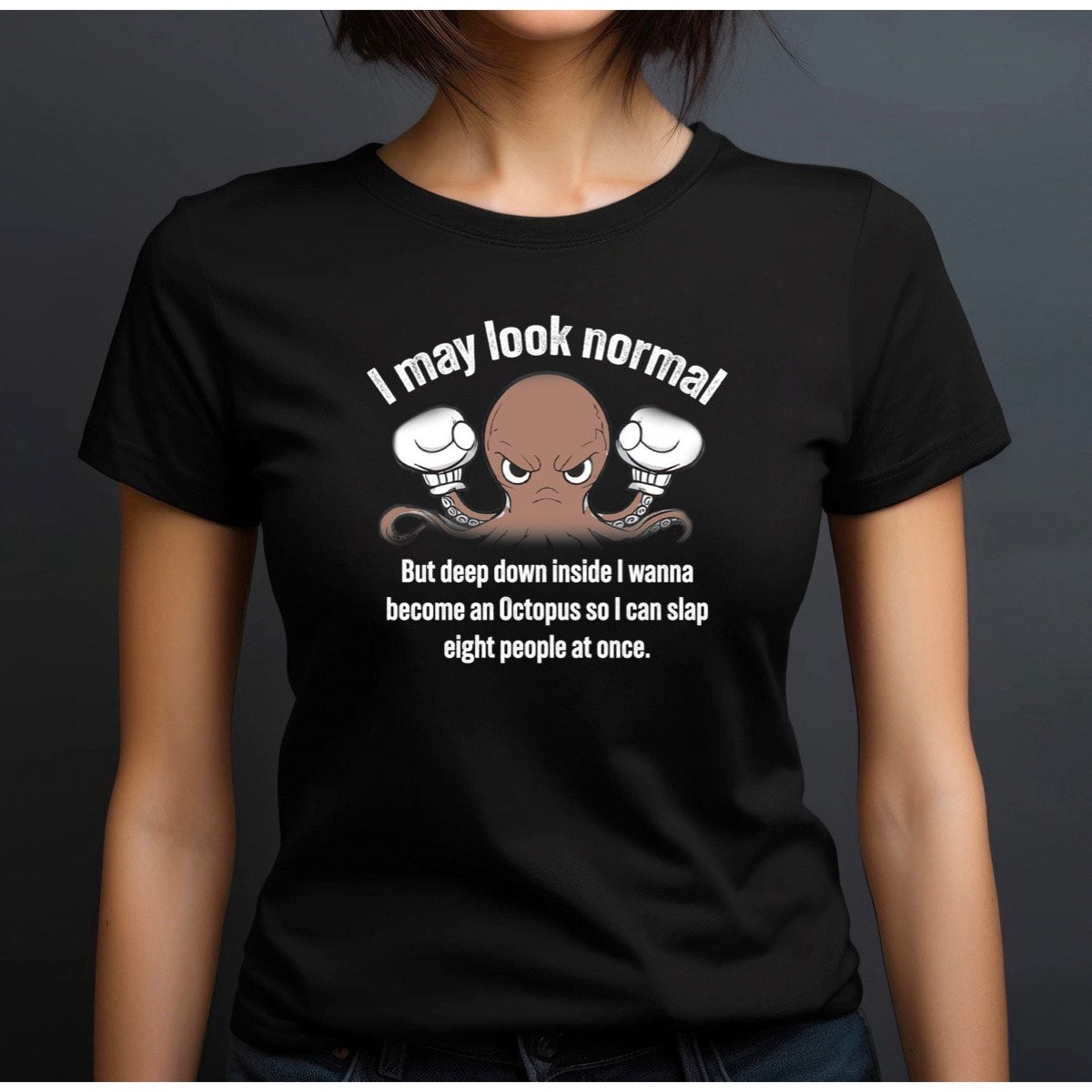 Woman wearing black crewneck t-shirt with angry octopus cartoon and I may look normal funny quote, studio portrait