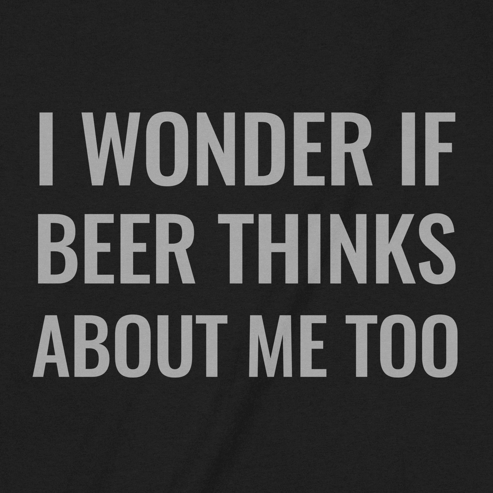 Closeup of black t-shirt with bold white text reading I wonder if beer thinks about me too