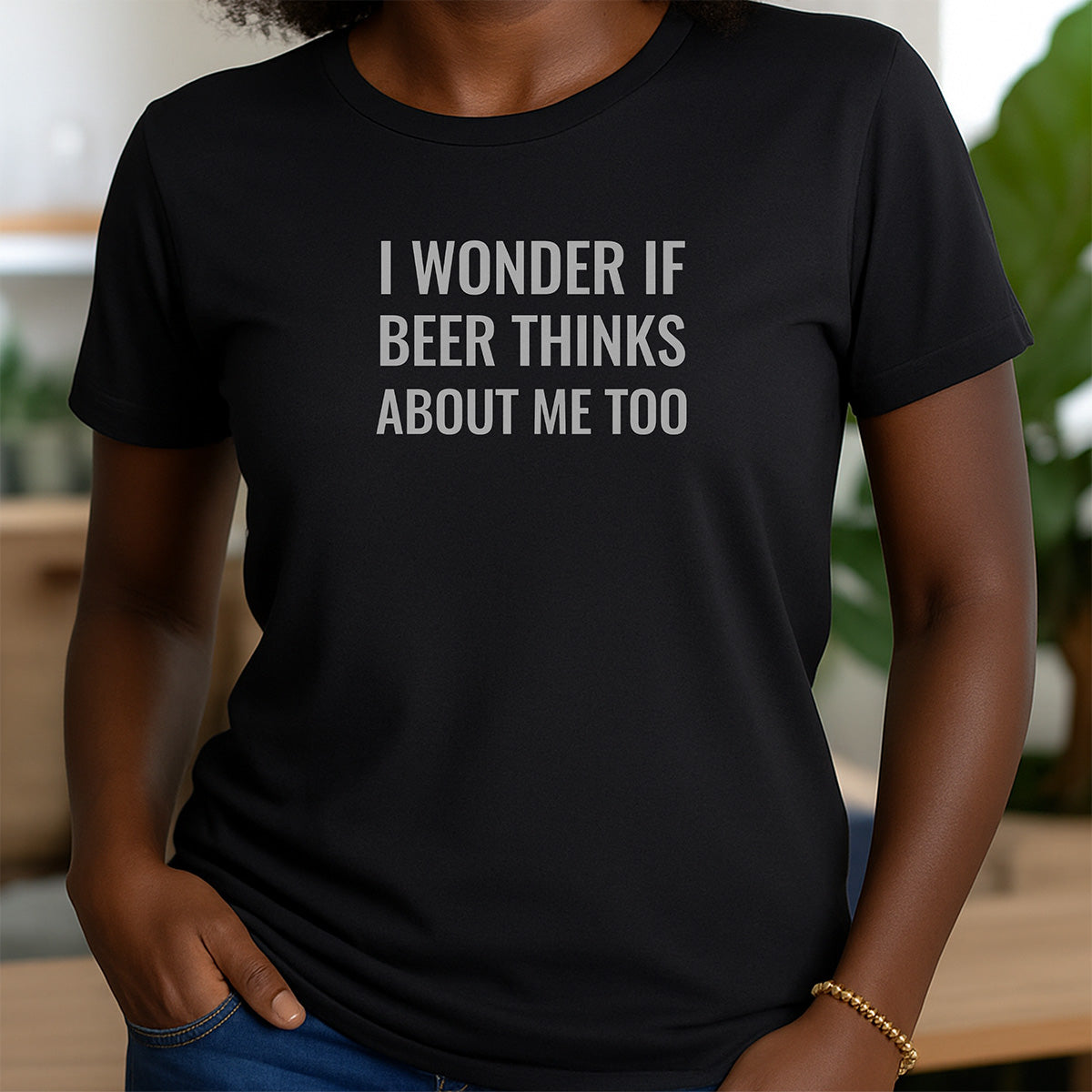 Woman in black crewneck shirt with humorous text I wonder if beer thinks about me too
