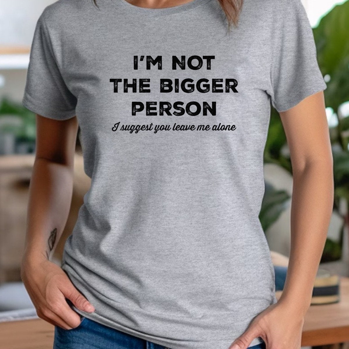 Woman wearing heather gray crewneck tee with bold quote I’m not the bigger person, I suggest you leave me alone