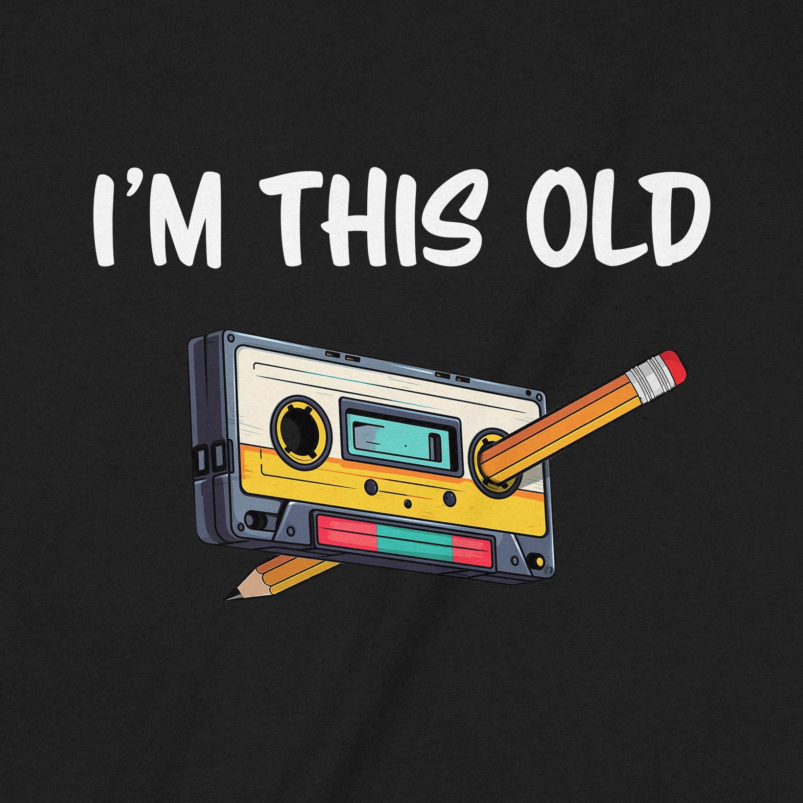 Closeup of black shirt with colorful cassette tape and pencil graphic with I’m this old caption