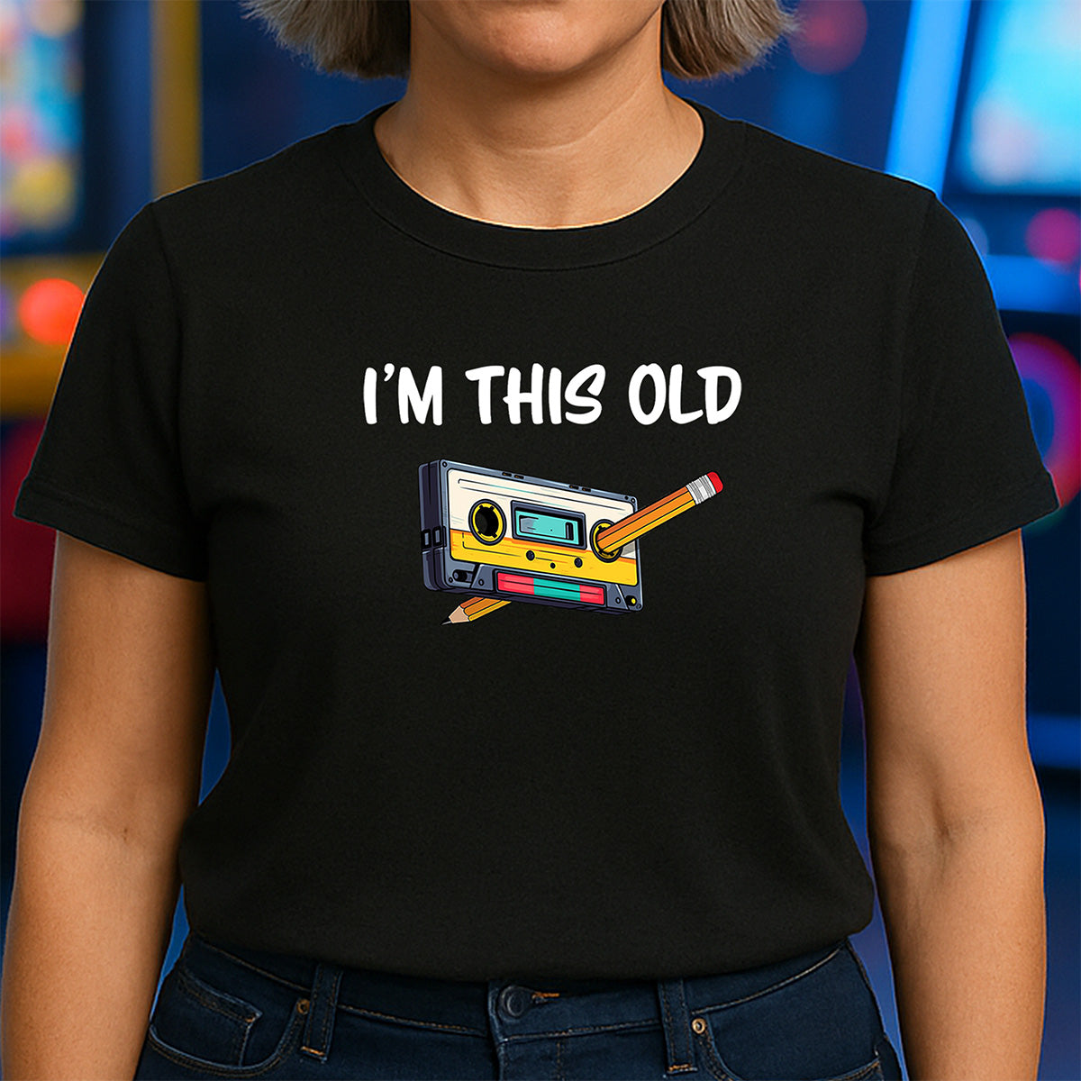Woman in black crew neck t-shirt with vintage cassette tape and pencil design and I’m this old wording