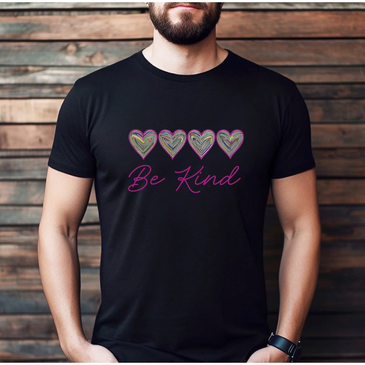 Man wearing black Be Kind t-shirt with colorful hearts and pink script lettering