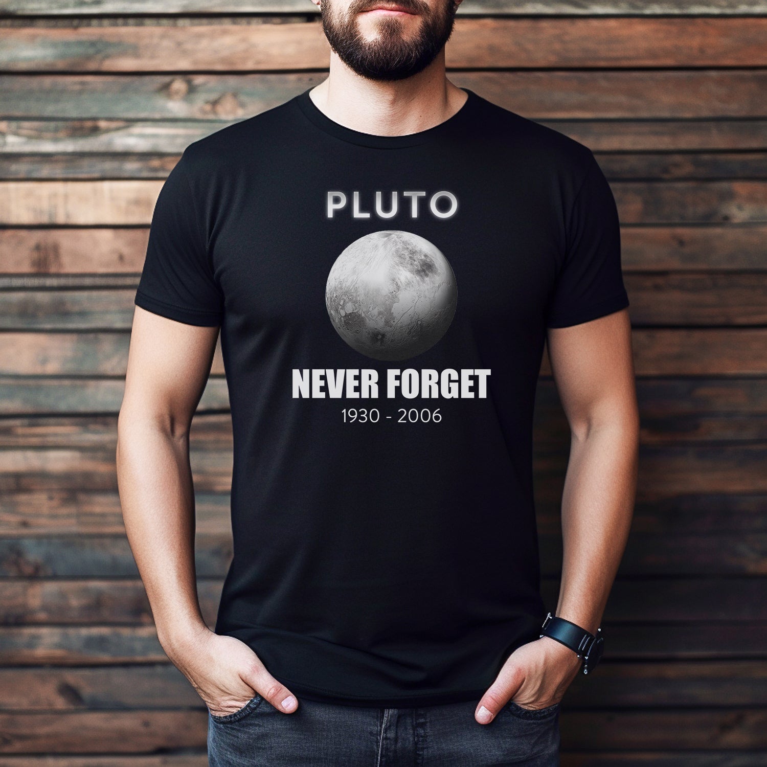 Man wearing black graphic t-shirt with Pluto illustration and text “Pluto Never Forget 1930–2006.”