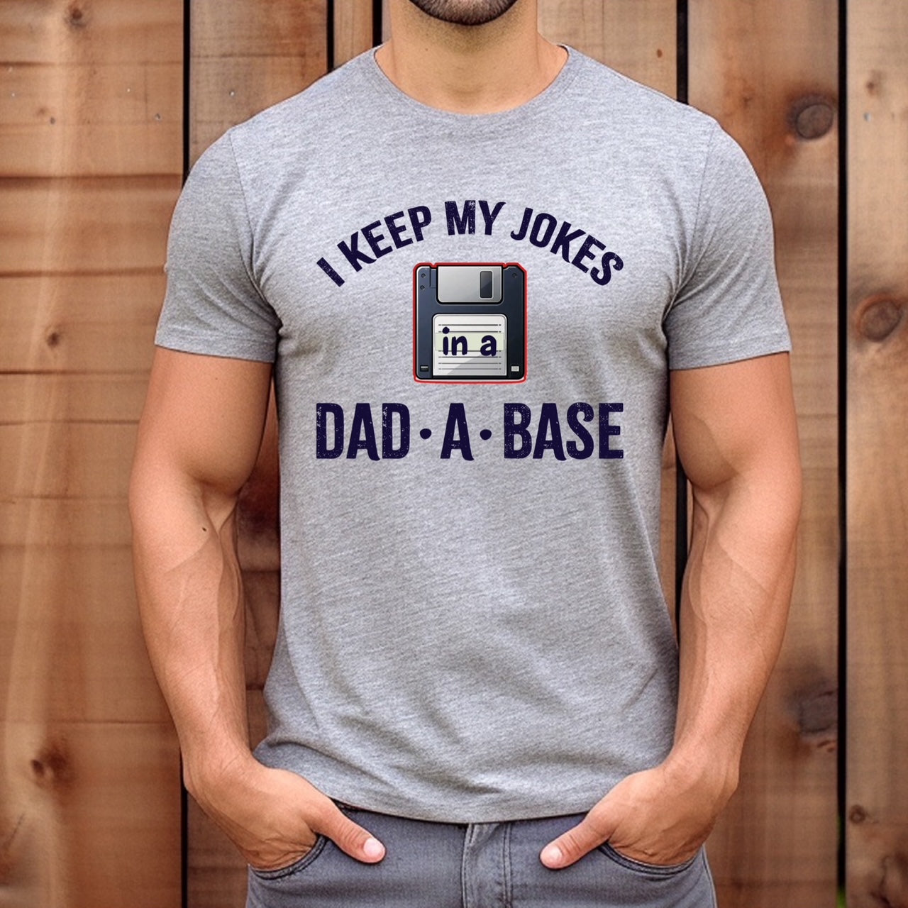 Man wearing grey dad joke t-shirt with floppy disk graphic and text I keep my jokes in a dad-a-base