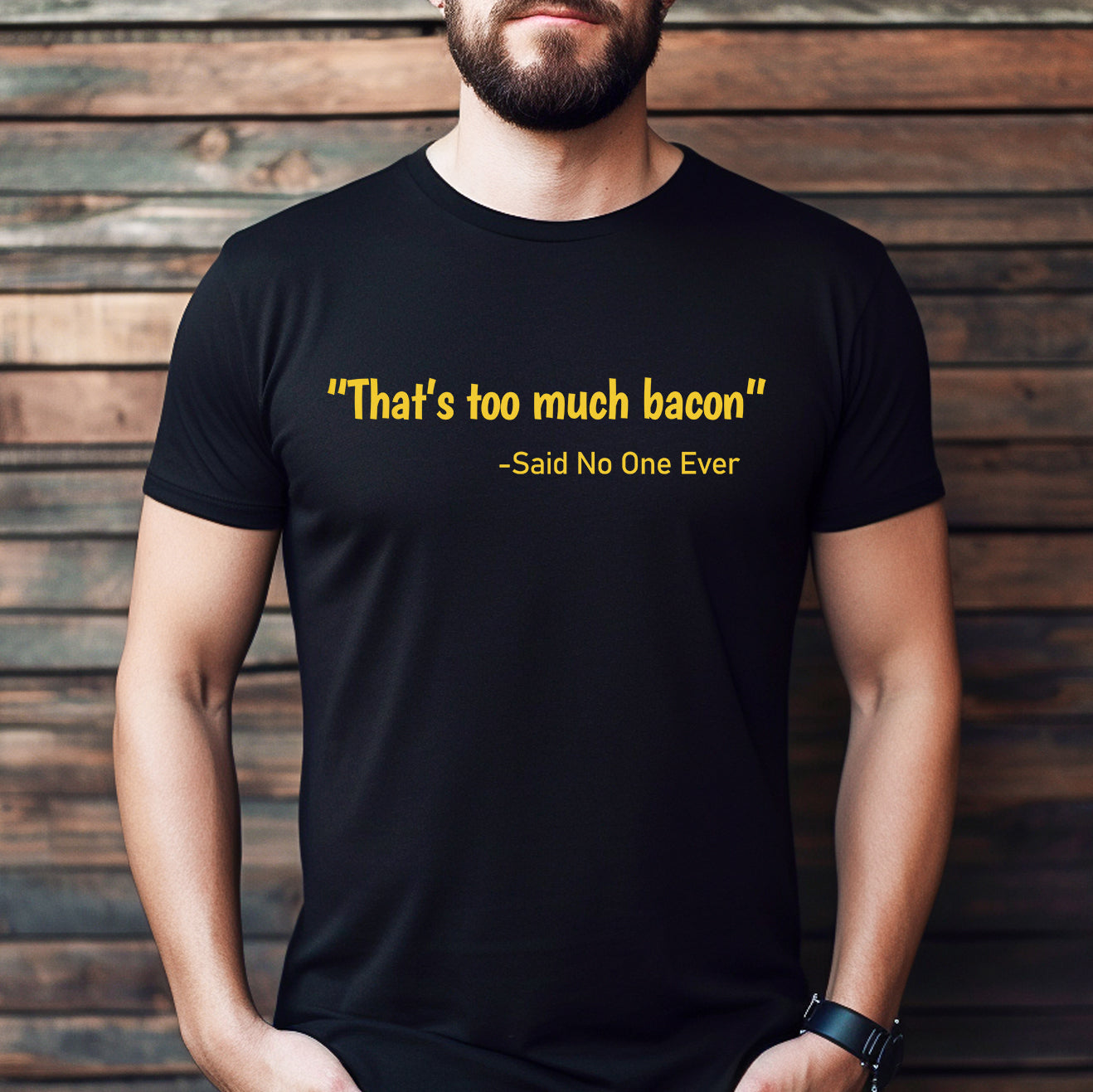 Man wearing black t-shirt with yellow text that says That's too much bacon said no one ever standing by wood wall
