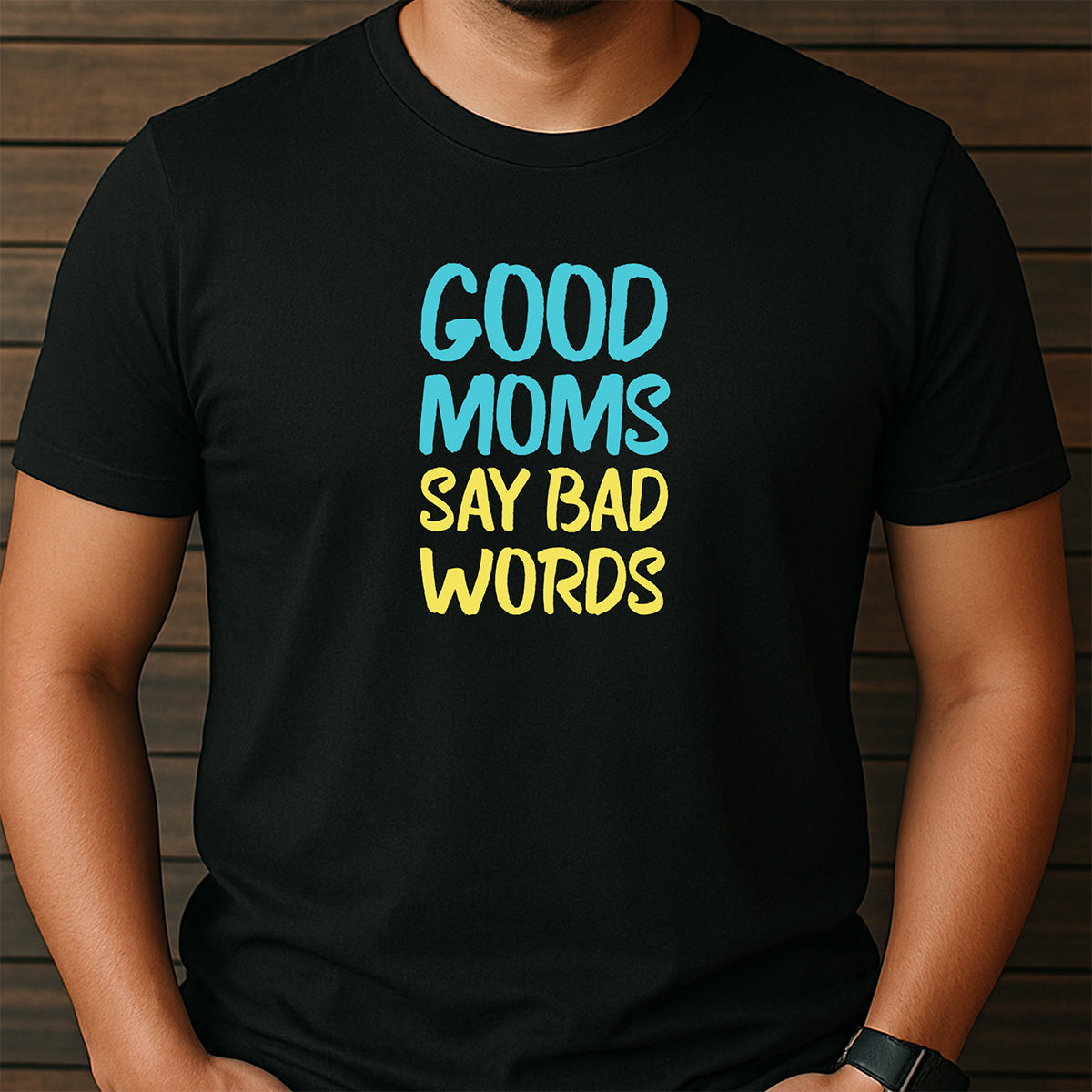 Man in black crew neck graphic tee with text Good Moms Say Bad Words in colorful blue and yellow font