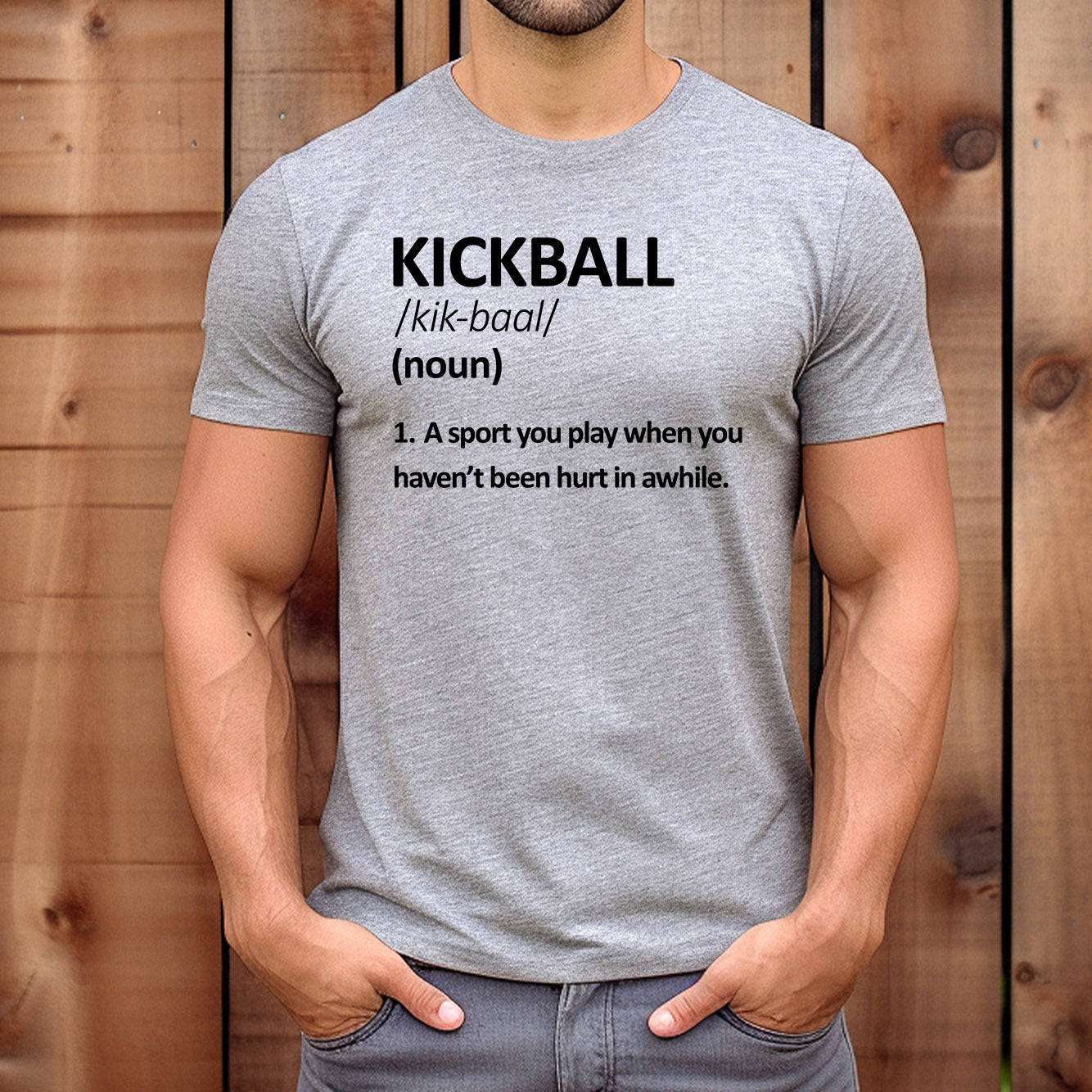 Man wearing grey kickball definition graphic tee with funny sports-inspired quote outdoors.