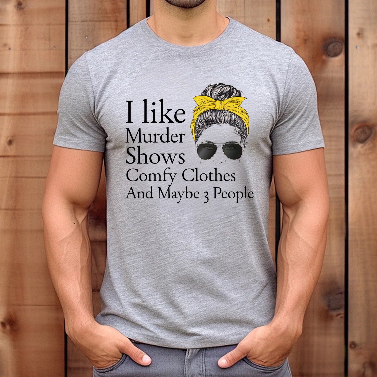 Men’s heather gray tee with Murder Shows Comfy Clothes And Maybe 3 People quote, wood background mockup