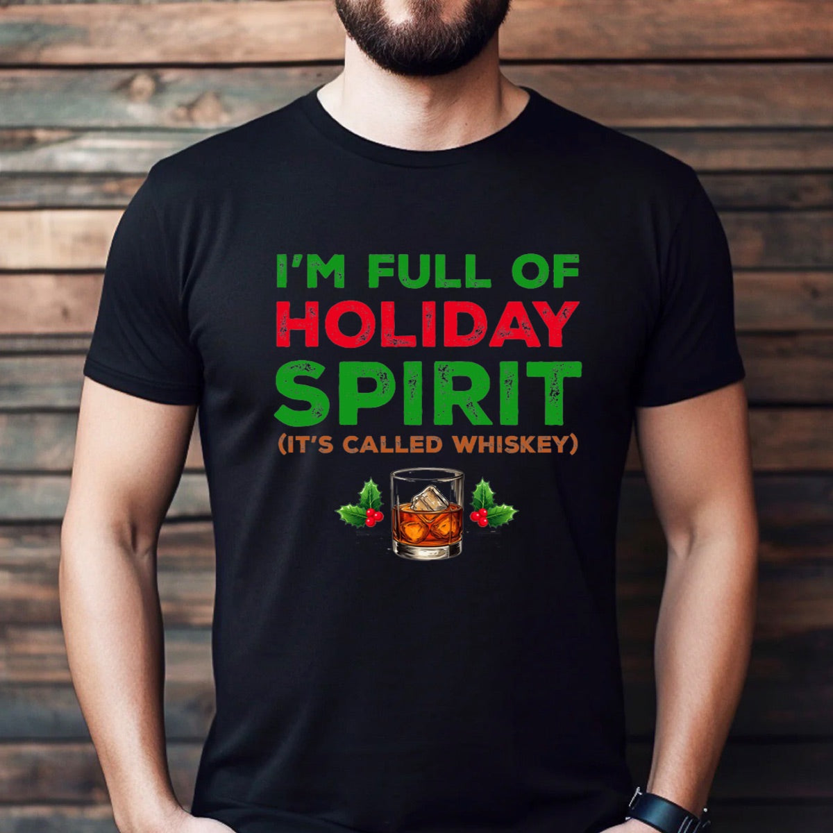 Man wearing black holiday spirit whiskey Christmas t-shirt with bold festive text and whiskey glass design