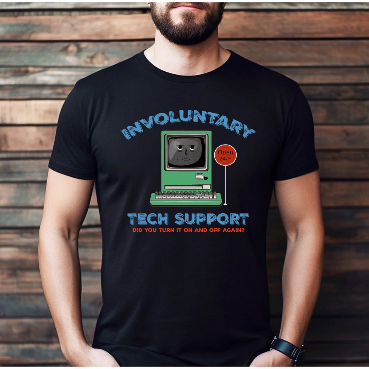 Man wearing black t-shirt with retro computer and humorous involuntary tech support slogan
