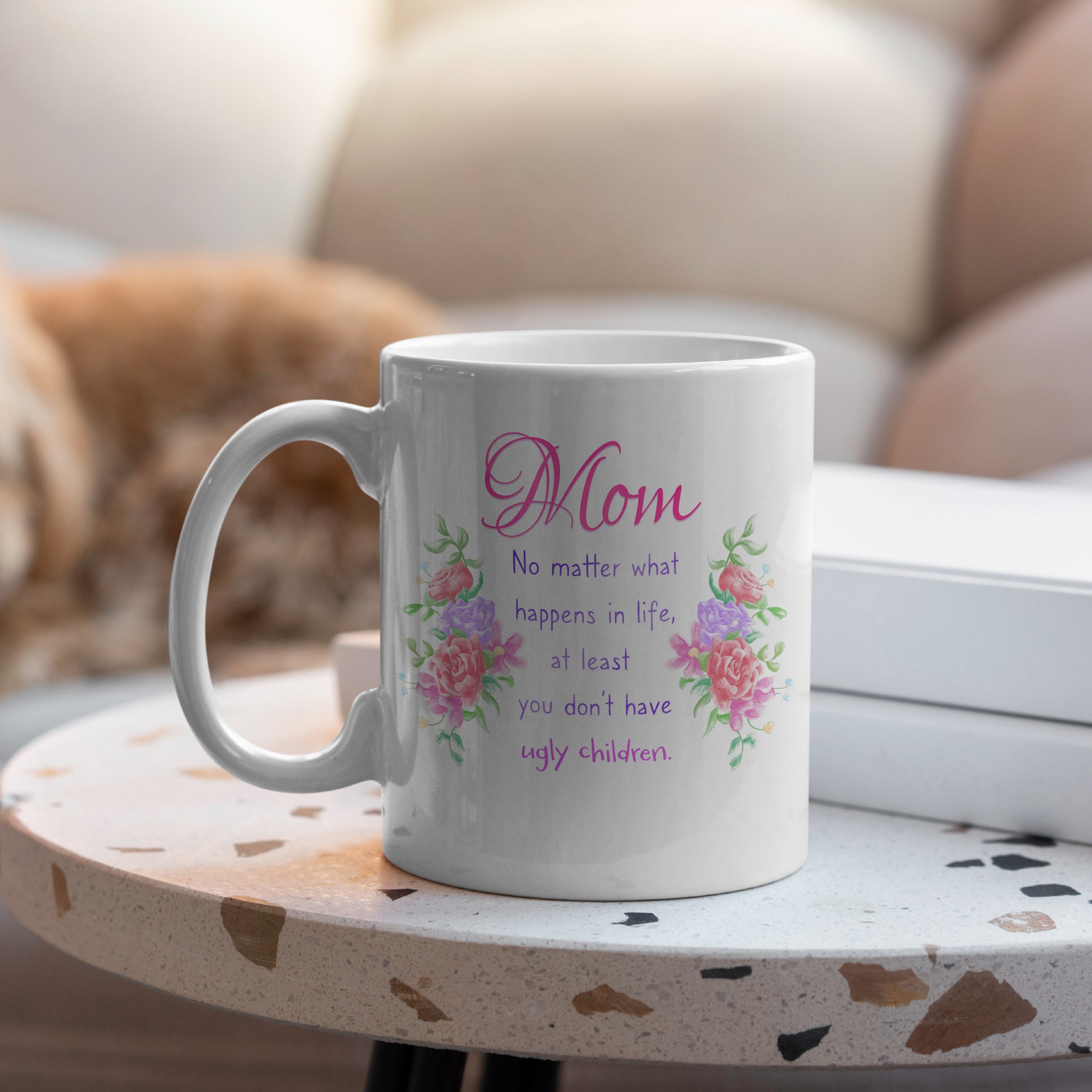 White ceramic mom mug on table with floral MOM design and humorous saying 