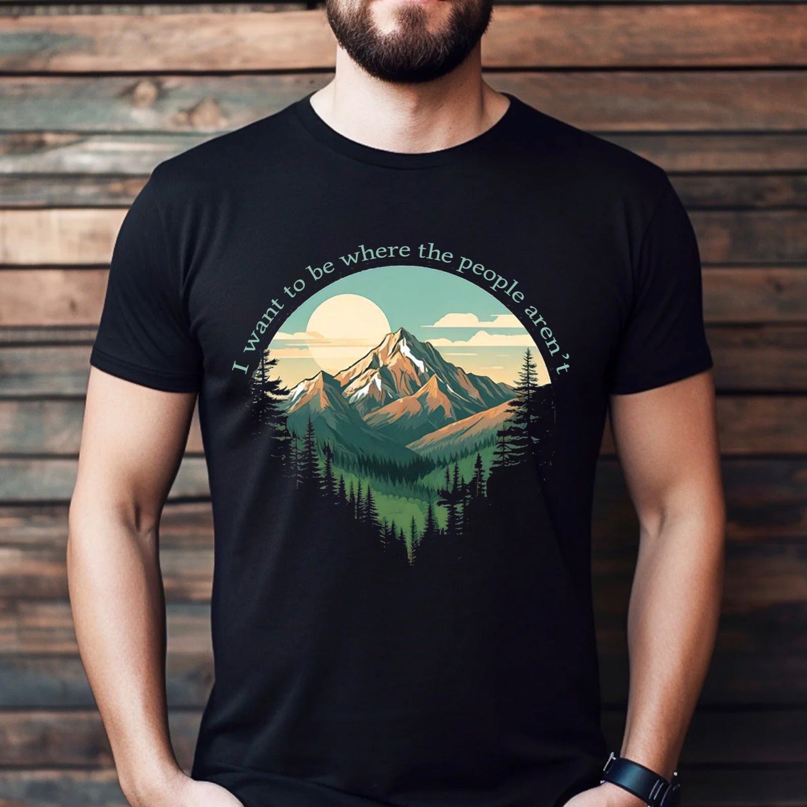 Man wearing black t-shirt with mountain sunset graphic and quote I want to be where the people aren't