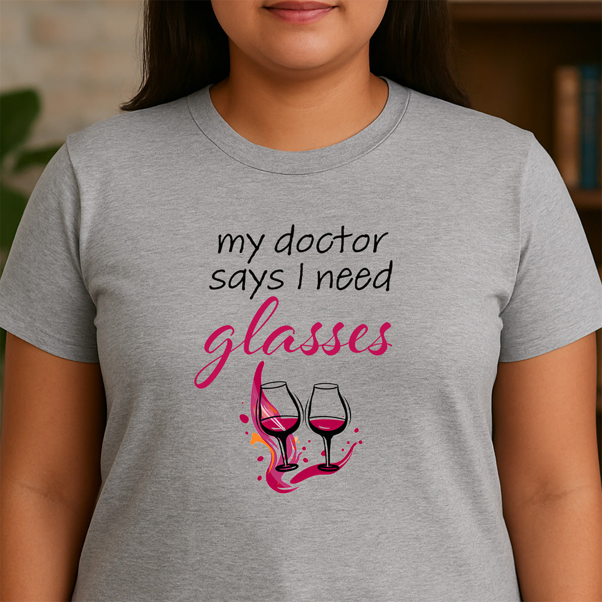 Woman in heather gray crewneck tee reading my doctor says I need glasses with two wine glasses illustration