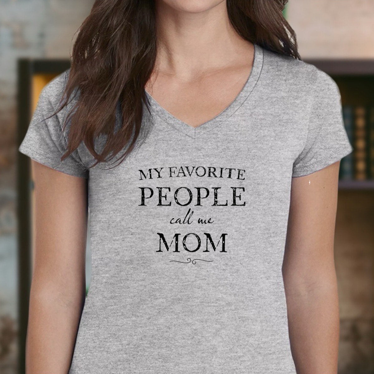 Woman wearing heather gray v-neck t-shirt with text My favorite people call me mom, close framing portrait