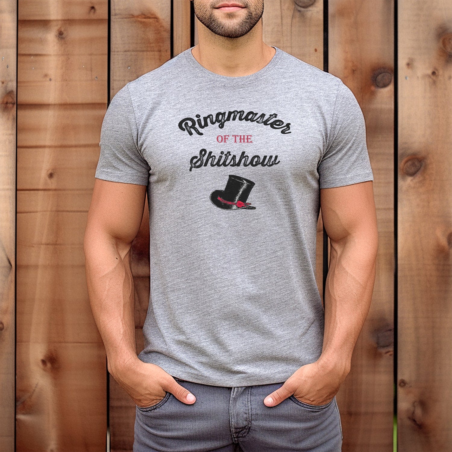 Man wearing heather gray Ringmaster of the Shitshow T-shirt with vintage top hat graphic, casual outdoor view