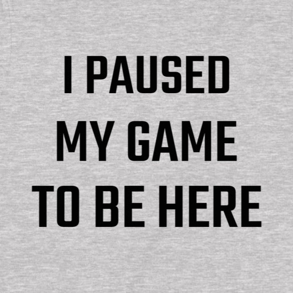 Closeup of grey gamer t-shirt with bold black text I Paused My Game To Be Here, gaming humor apparel