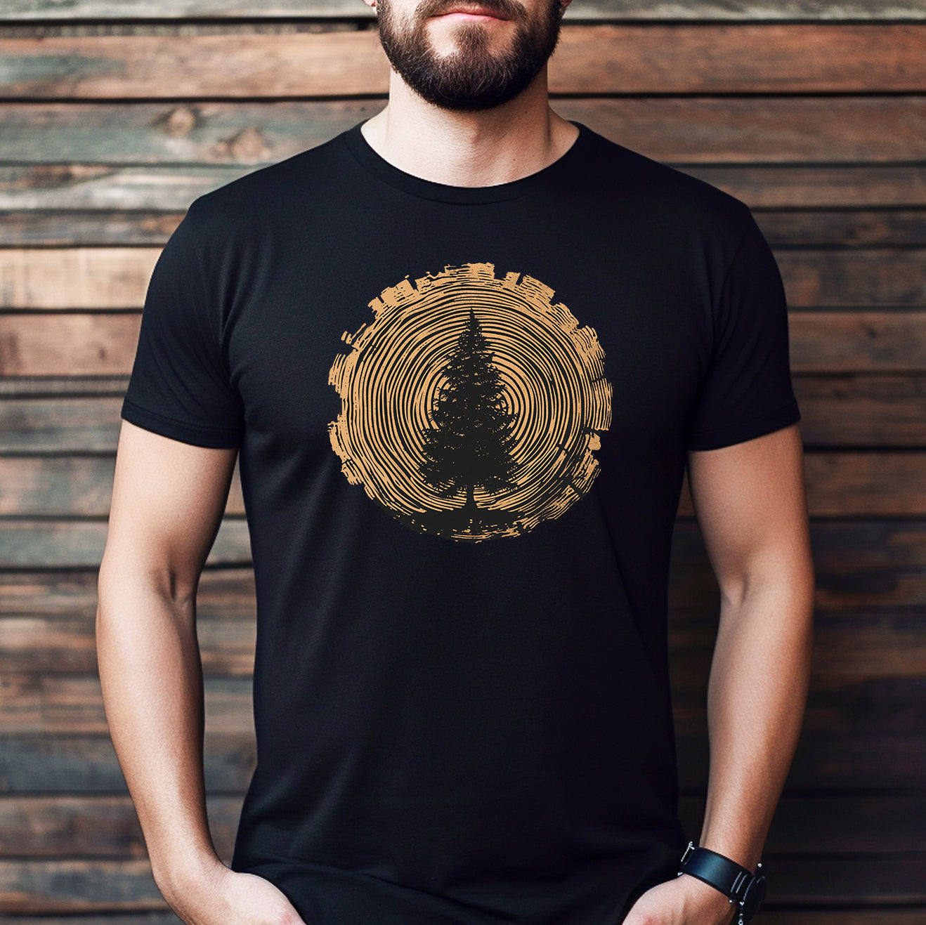 Man wearing a black t-shirt featuring a pine tree inside concentric tree rings, vintage woodcut style.