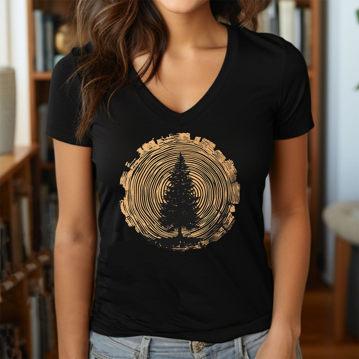 Woman in black V-neck shirt with pine tree and tree-ring woodcut circle graphic.