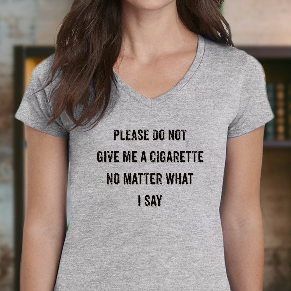 Woman wearing heather gray v-neck t-shirt reading Please do not give me a cigarette, close framing portrait